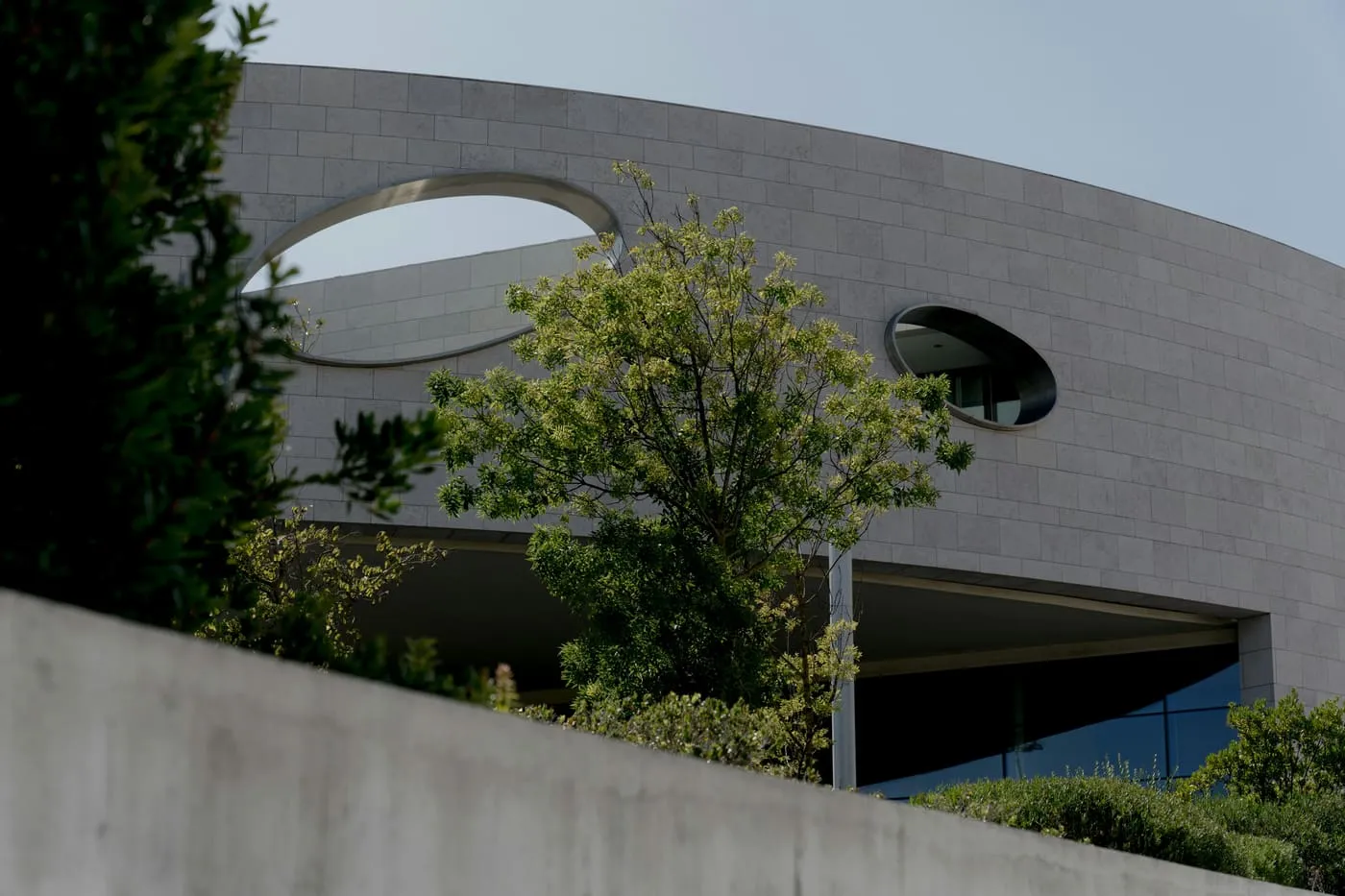 A curved facade clad in grey rectangular stone tile.